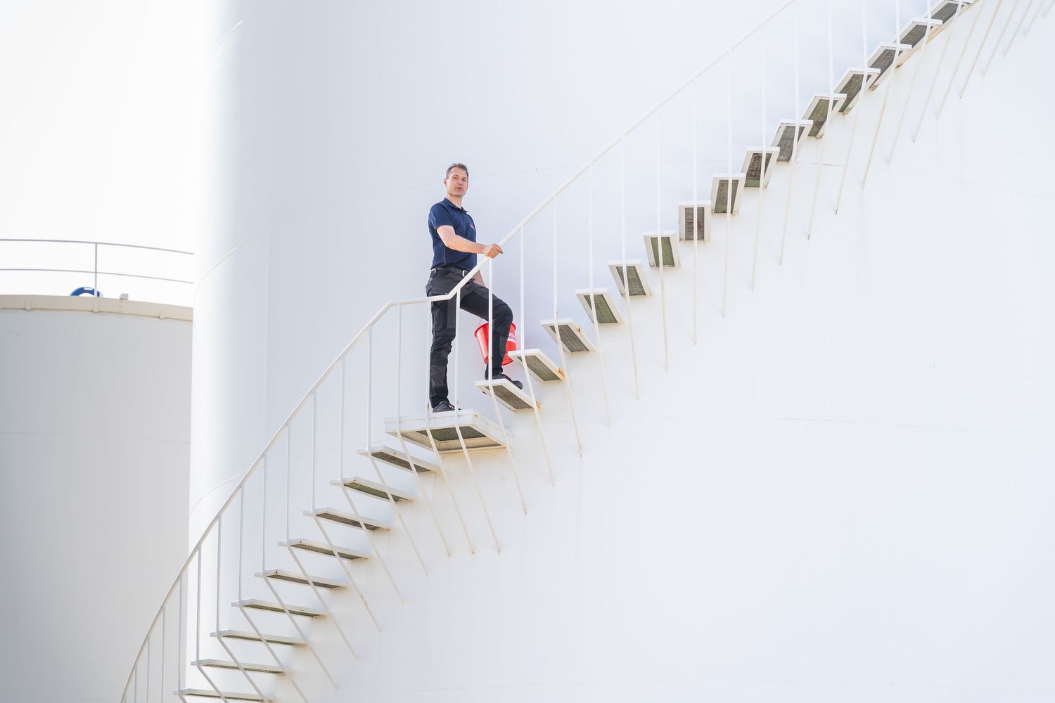 Modern white staircase with floating wooden steps against a minimalist white wall.