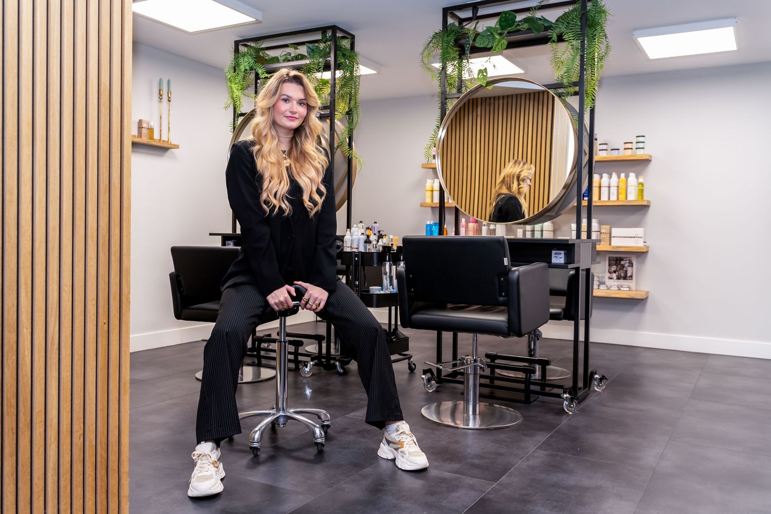 Contemporary salon space with wood paneling and professional styling stations.