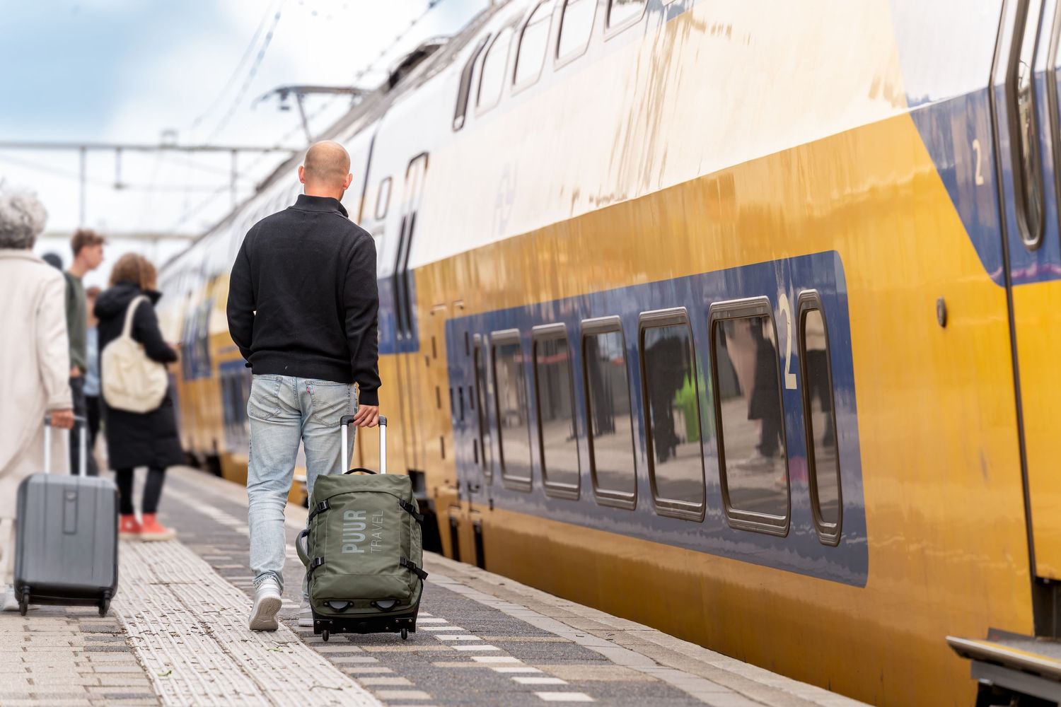 Yellow and white passenger train cars lined up at a station platform.