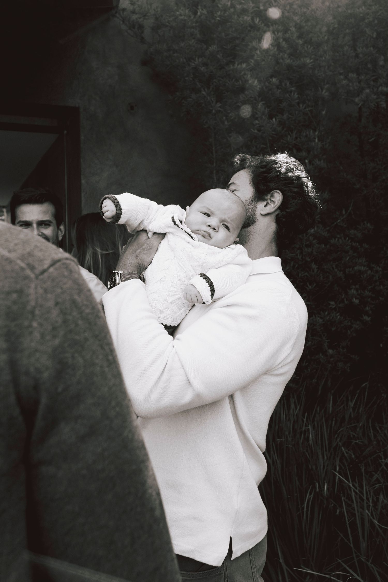 A sequence of black and white photos showing two people in white clothing embracing in an outdoor setting.