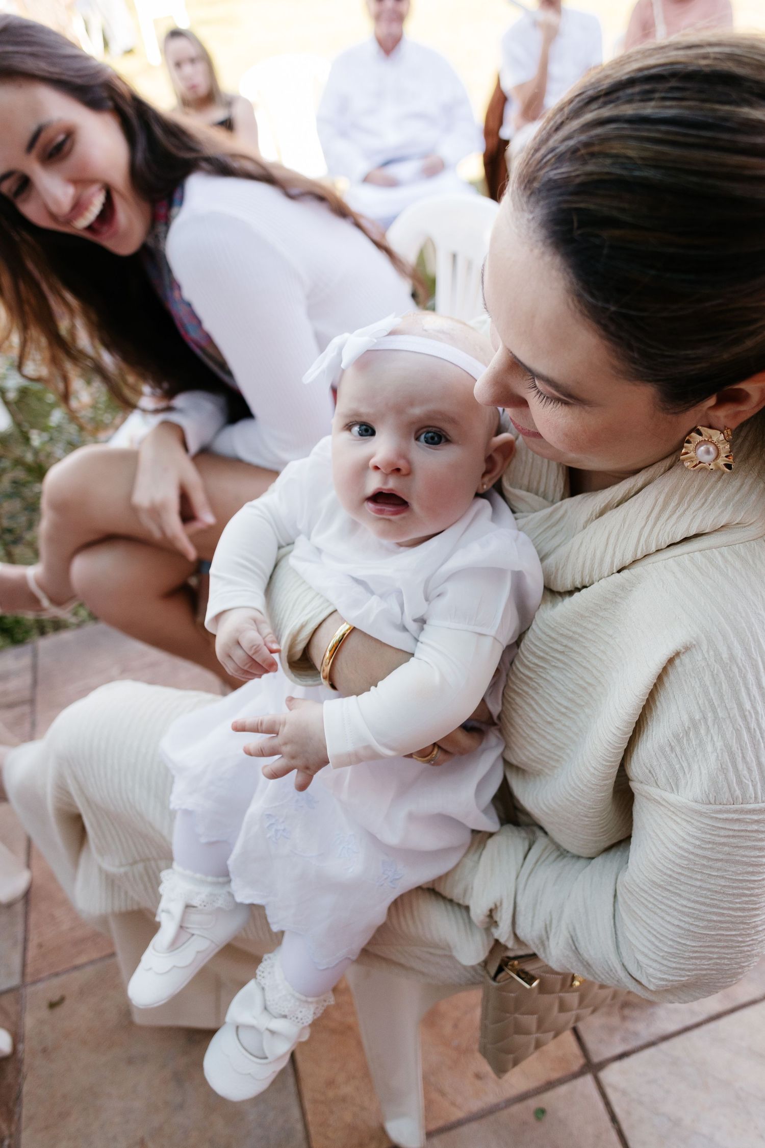 A series of tender moments showing a parent in a cream sweater holding and interacting with a baby in white clothing.