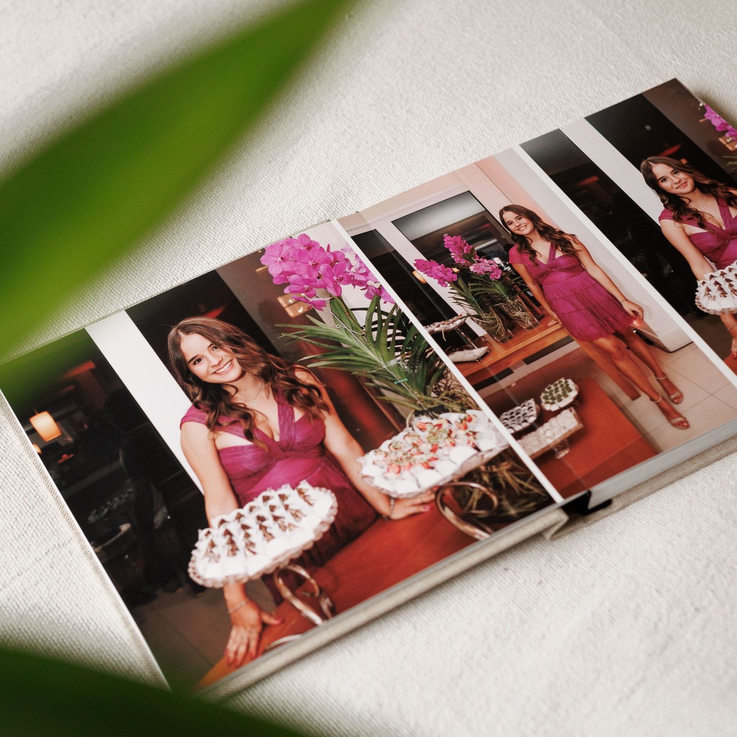 Photo album pages spread out showing a collection of personal memories and celebrations with pink decorative elements.
