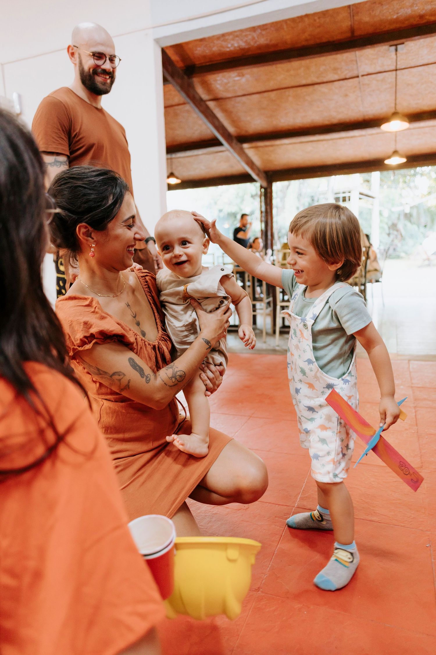 A joyful family gathering on a covered patio with vibrant orange and red tones in their casual attire.