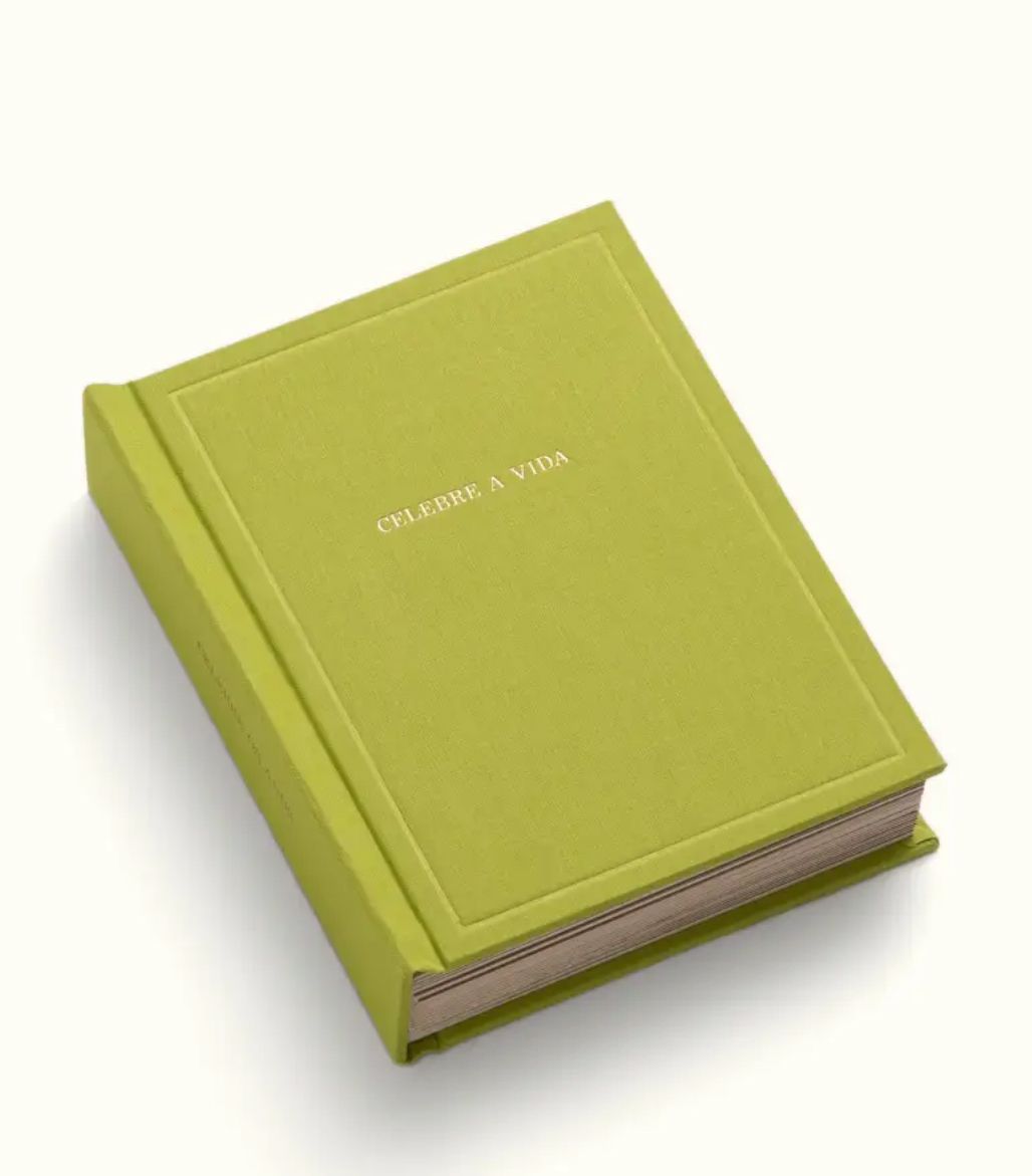 Green hardcover journal with gold embossed text reading Celebre a Vida, elegant minimalist design on white background.