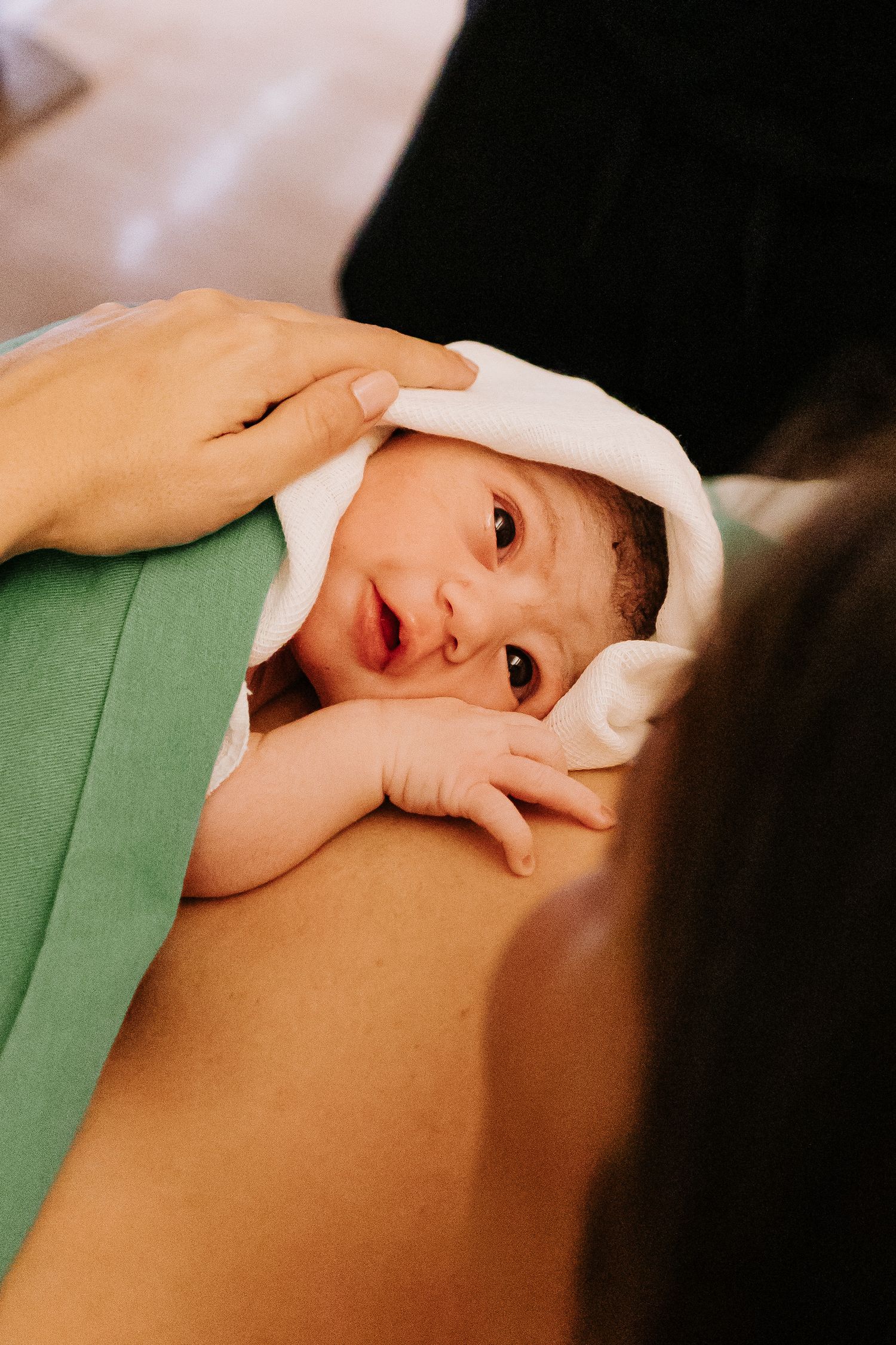 A newborn baby snuggles close during their first moments after birth.
