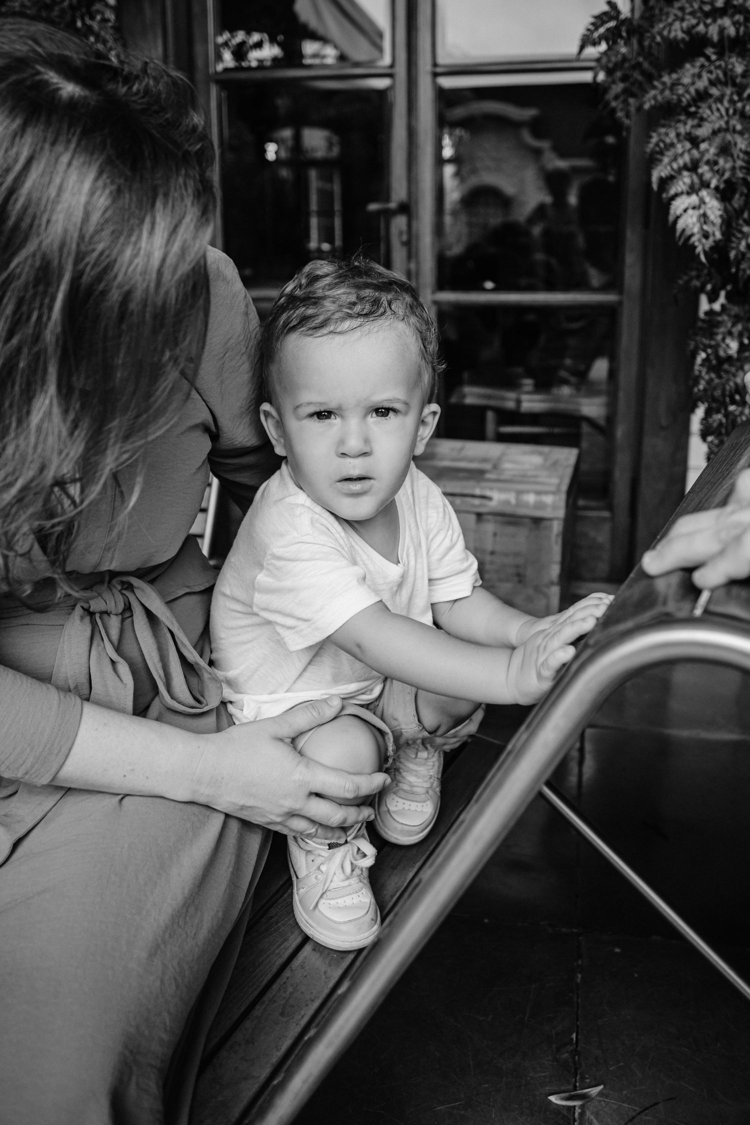 Black and white candid photo of a family moment at an outdoor dining area.