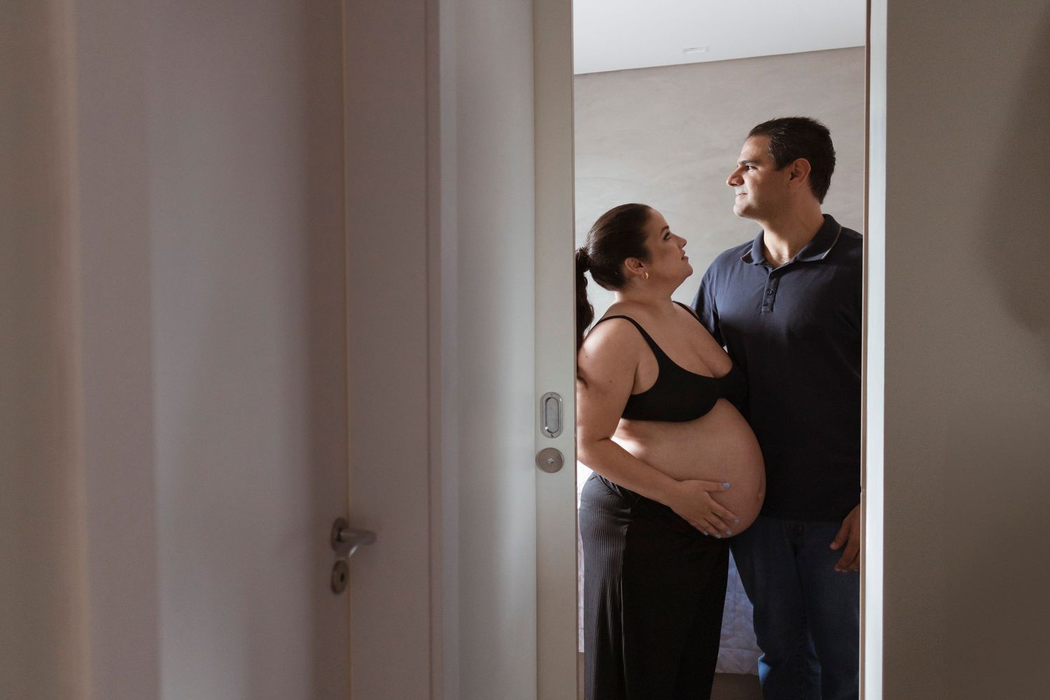 Series of photos showing a couple embracing and hugging in a dimly lit hallway.