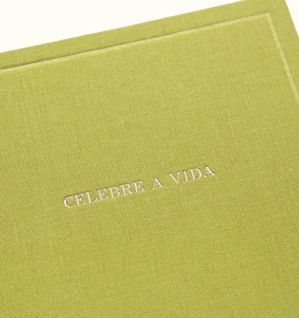 Green linen-textured journal with silver embossed text reading CELEBRE A VIDA, meaning Celebrate Life in Portuguese.