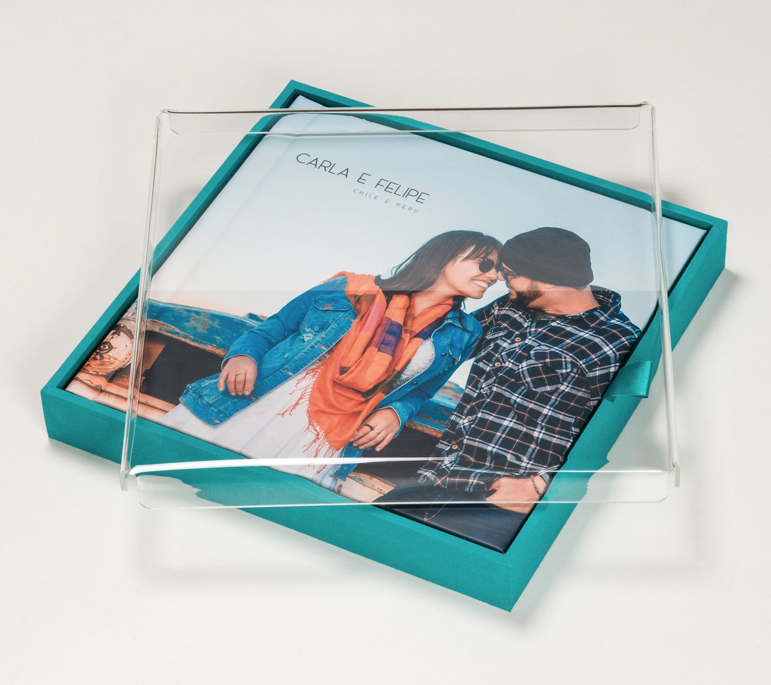 Acrylic photo frame displaying a couple portrait on a teal gift box, elegant keepsake presentation.