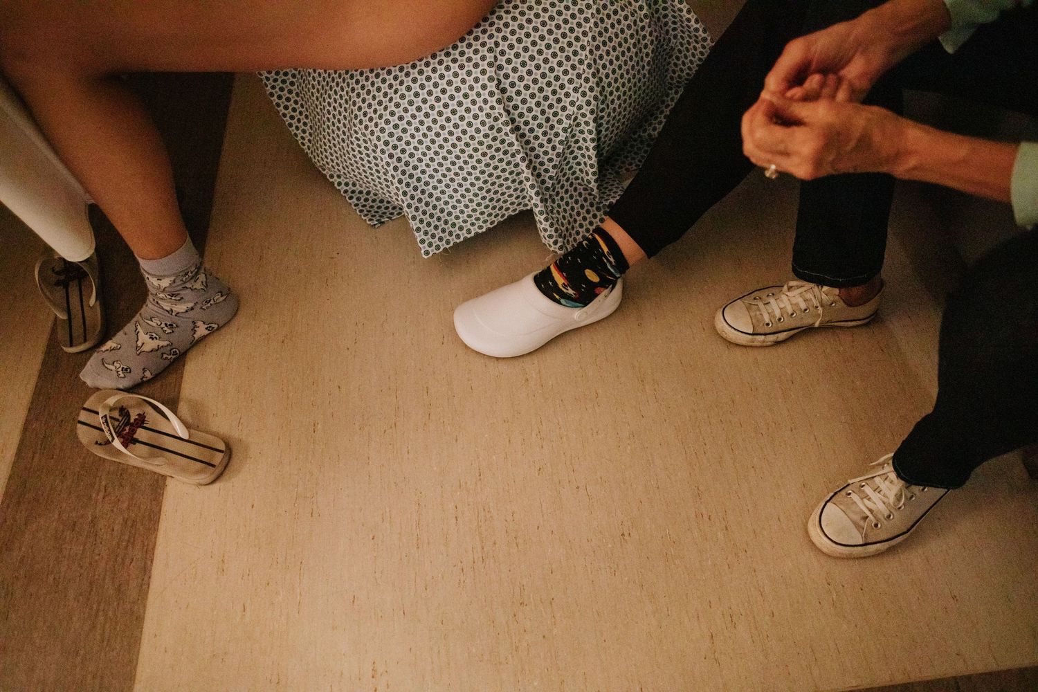 View of several pairs of sneakers on a beige floor.
