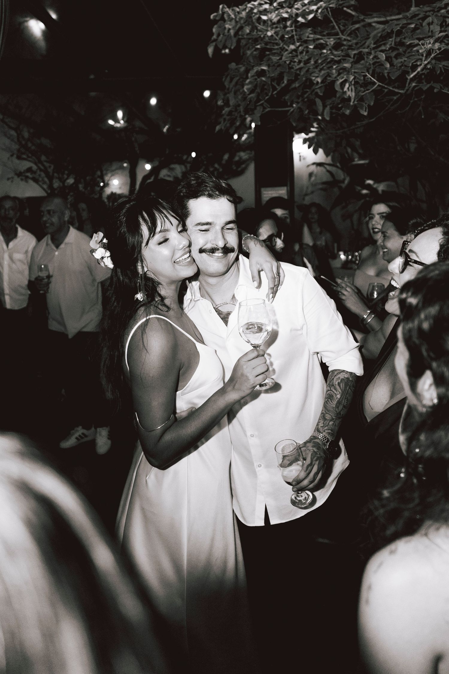 A couple sharing a romantic dance moment at a nighttime celebration.