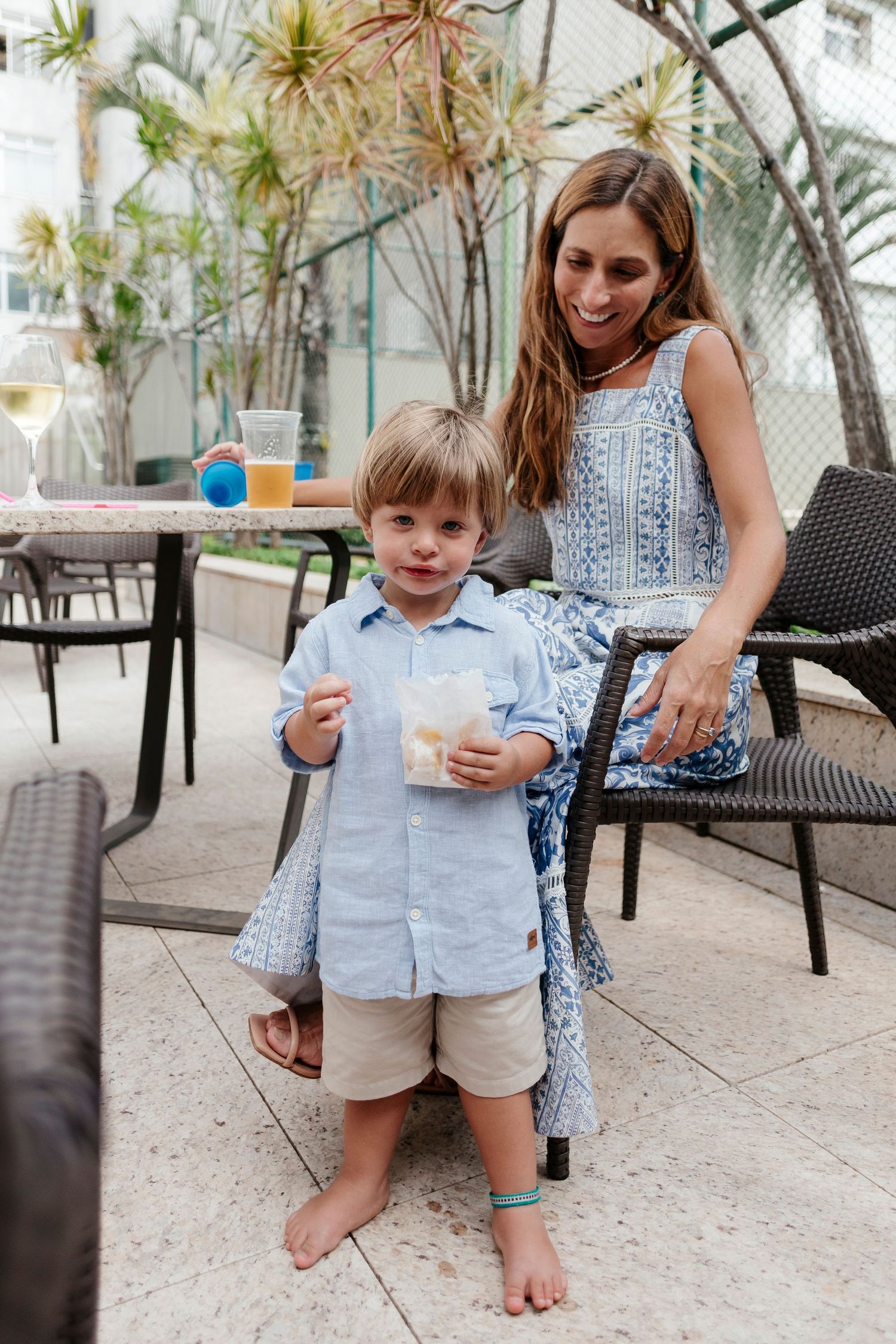 Casual outdoor scene on patio with palm trees in background.