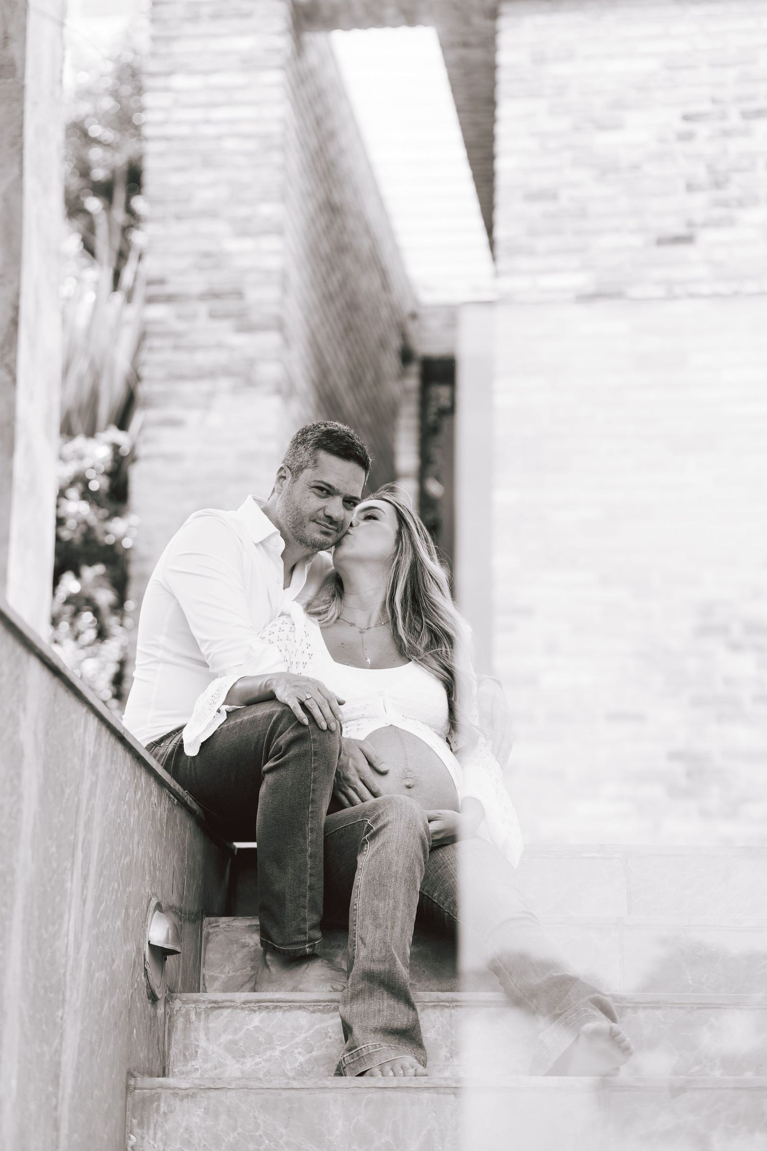 A romantic black and white photo sequence showing a couple sharing tender moments on outdoor steps.