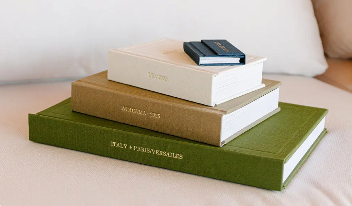 Stack of three travel photo books including Italy, Paris, and Versailles editions displayed on a neutral surface.