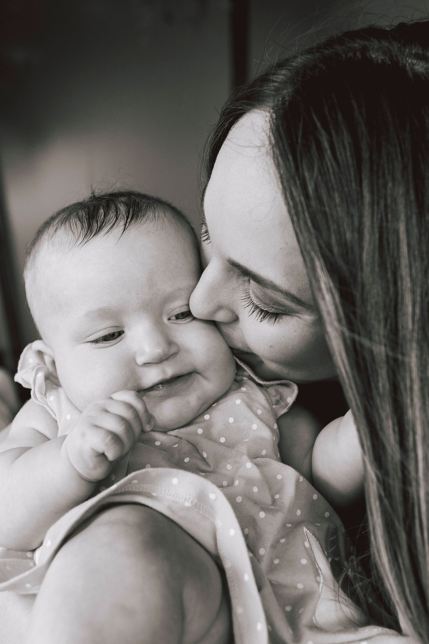 Intimate black and white portrait of mother and baby sharing tender moment.