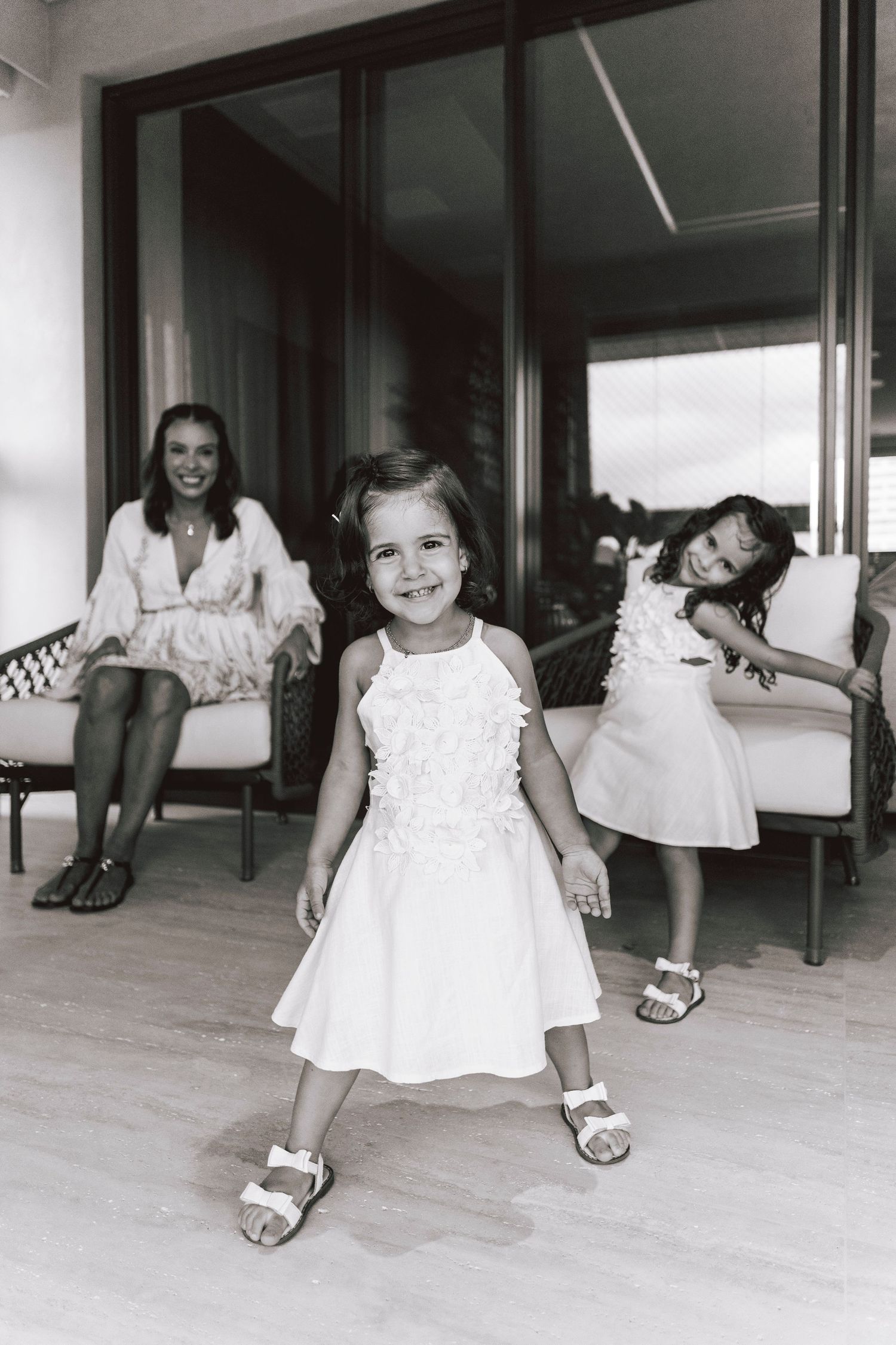 Black and white photo showing playful expressions in a modern indoor setting.
