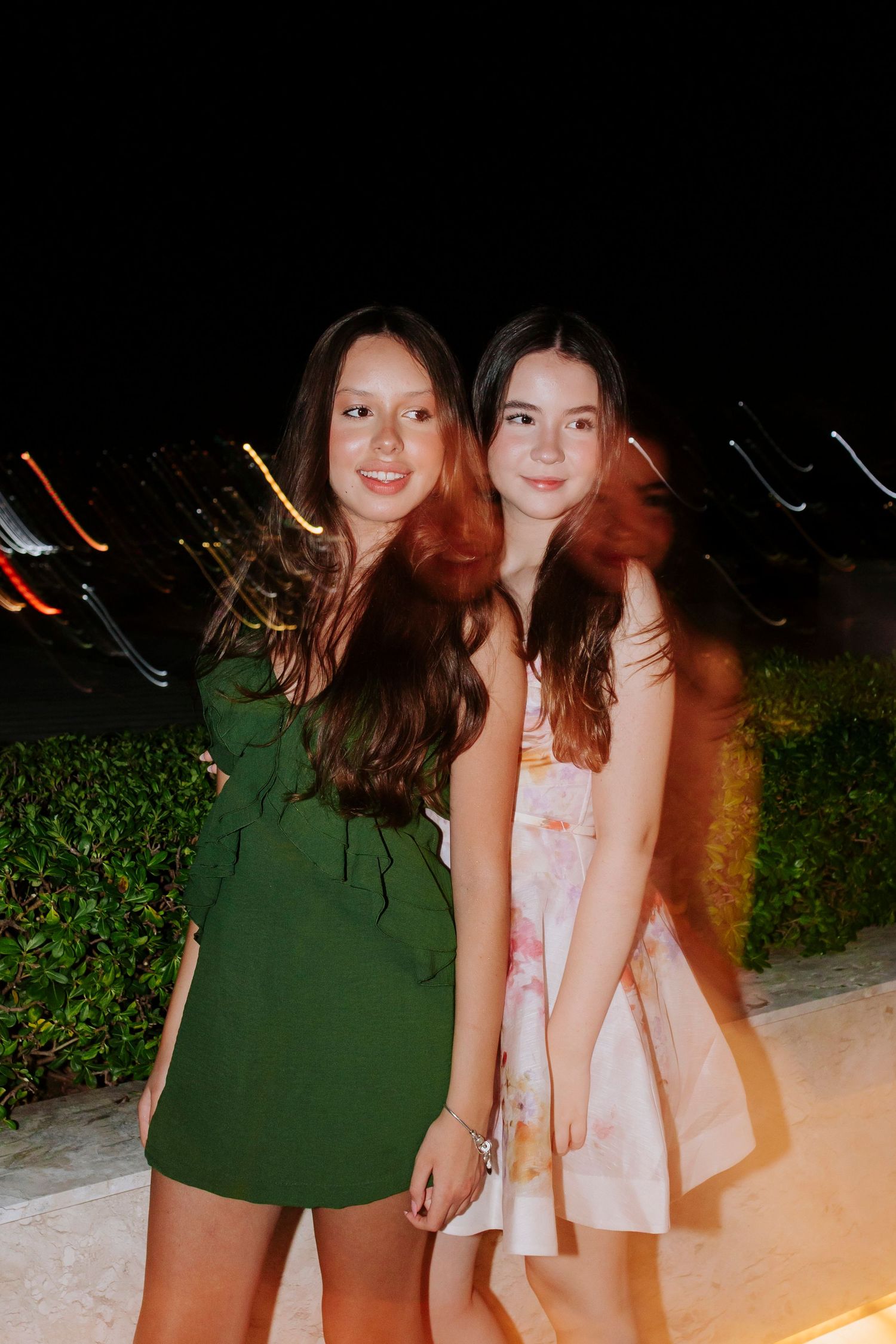 Nighttime outdoor photo with city lights creating a bokeh effect in the background.