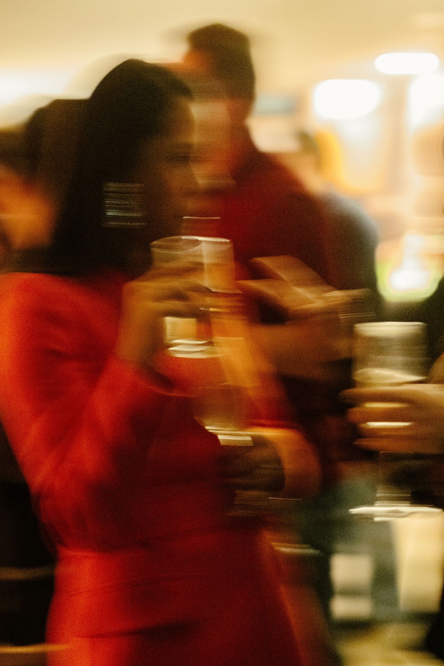 Motion-blurred sequence of dancers in red costumes performing on stage with warm lighting effects.