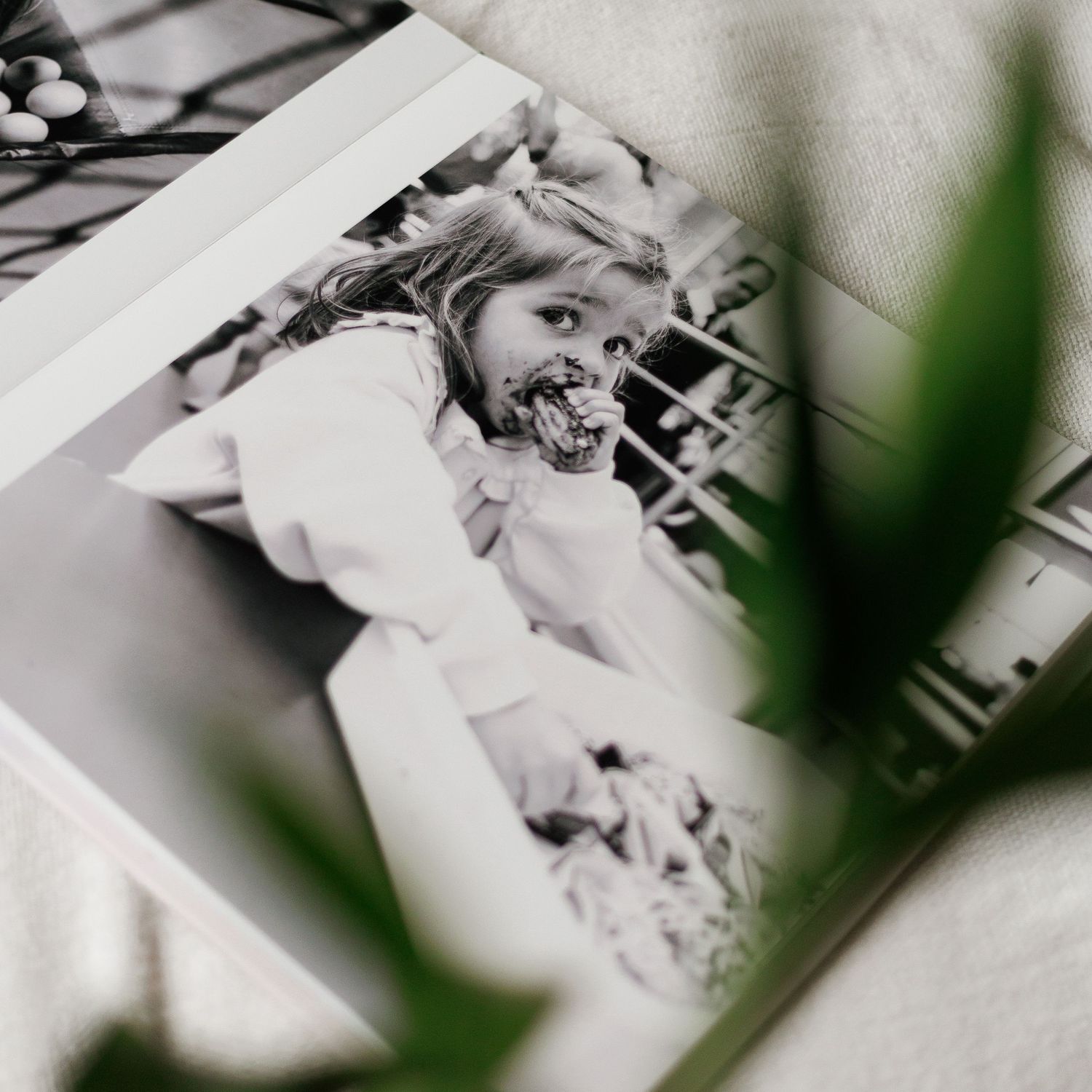 Black and white photo of a young girl smiling with chocolate on her face, wearing a white dress at a celebration.