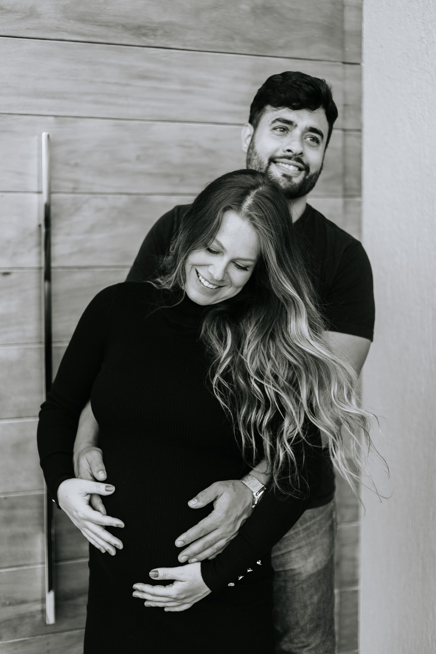 Black and white intimate portrait of expecting couple sharing tender moment.