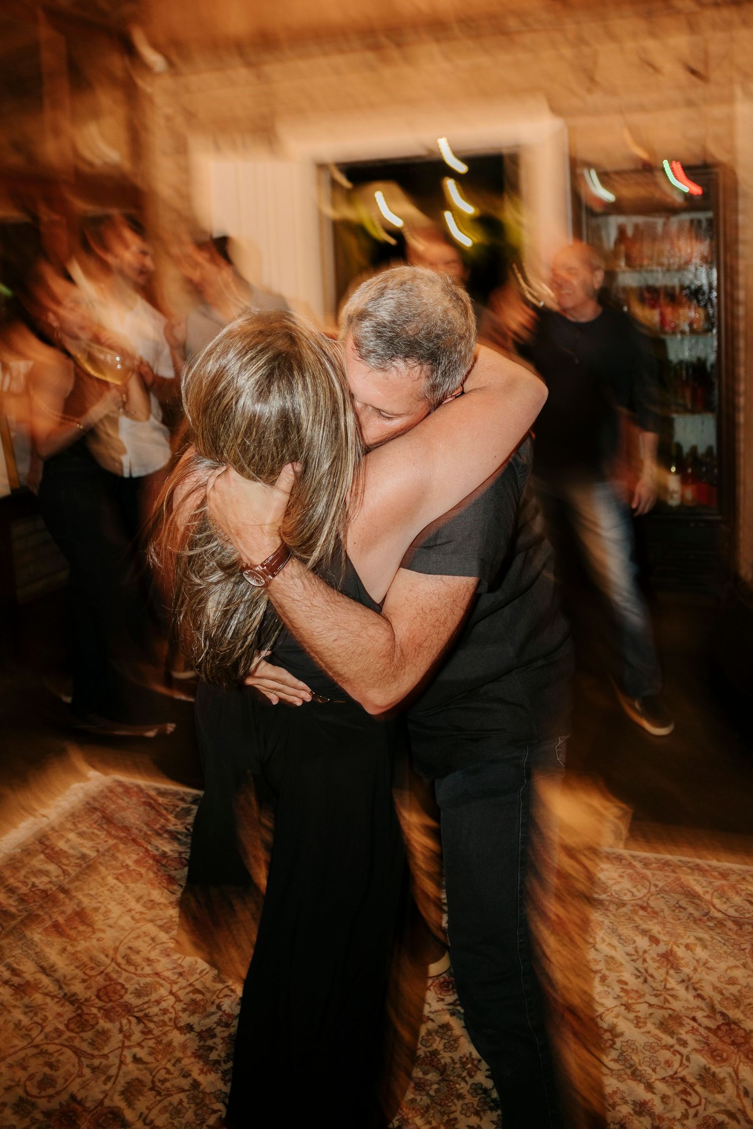 A dramatic dance dip captured in motion blur during an indoor celebration.