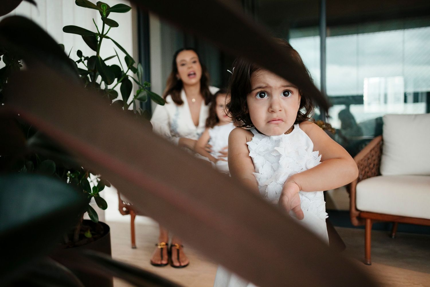 A candid moment captured through leaves in a modern interior setting.