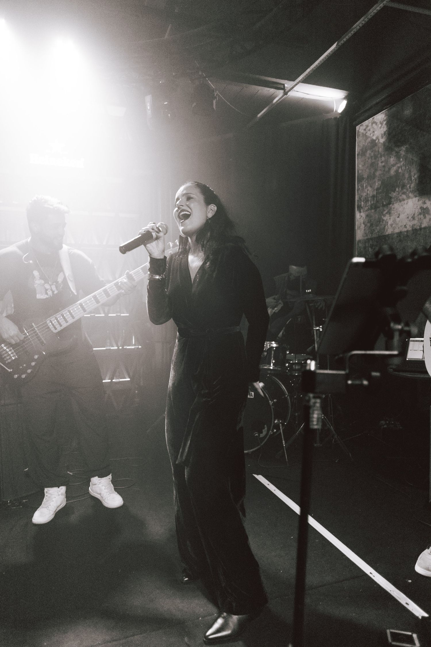 Atmospheric black and white concert photos showing performers on a dimly lit stage with dramatic lighting and fog effects.