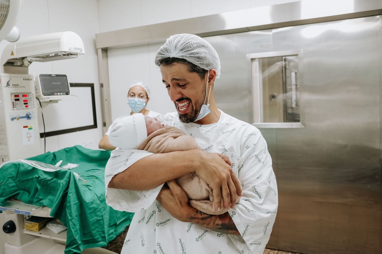 A joyful moment in a medical setting as a newborn is held for the first time.