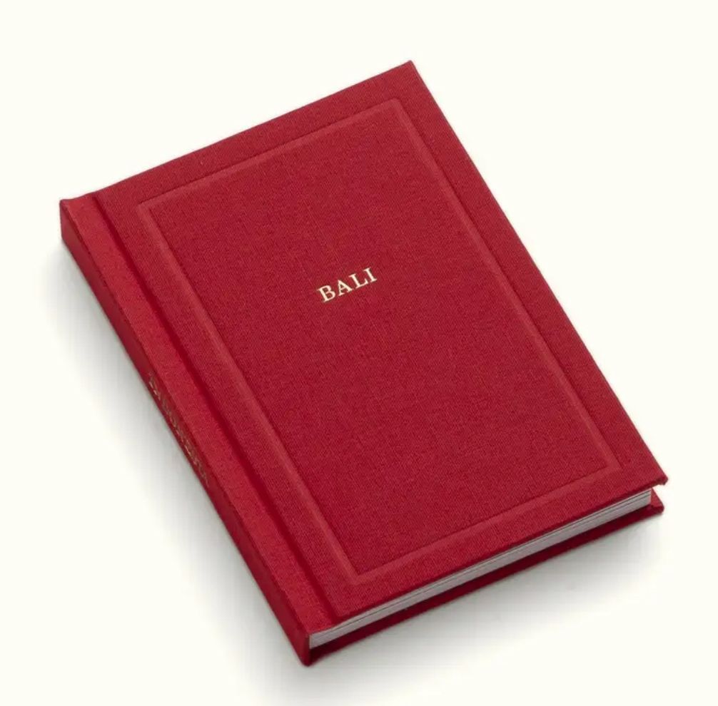 Red hardcover Bali journal book with gold embossed title and decorative border.