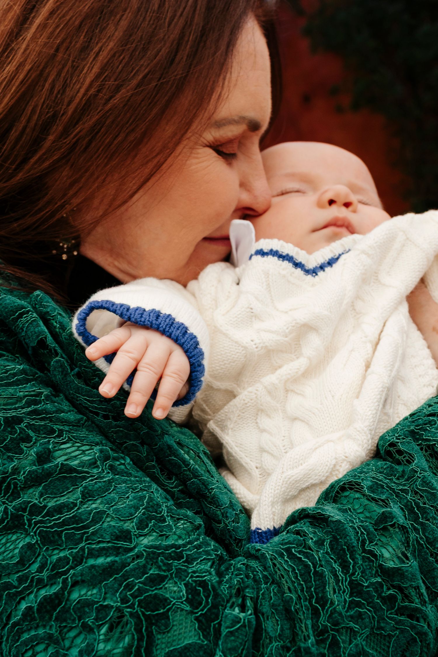 Close-up sequence showing a baby in white clothing resting on a dark green textured blanket.