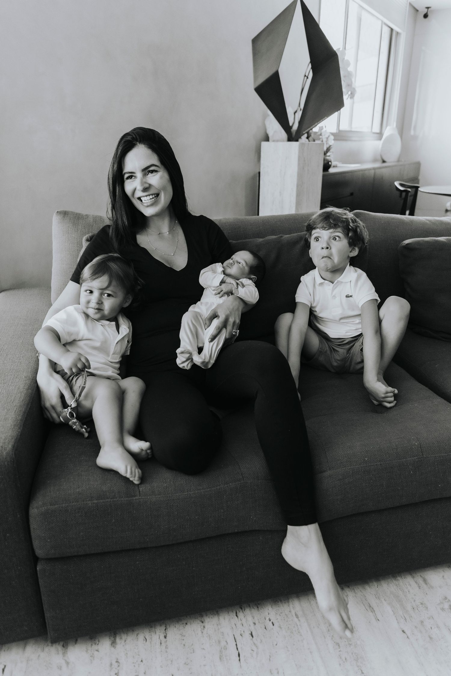 Family relaxing together on grey couch in minimalist living room.