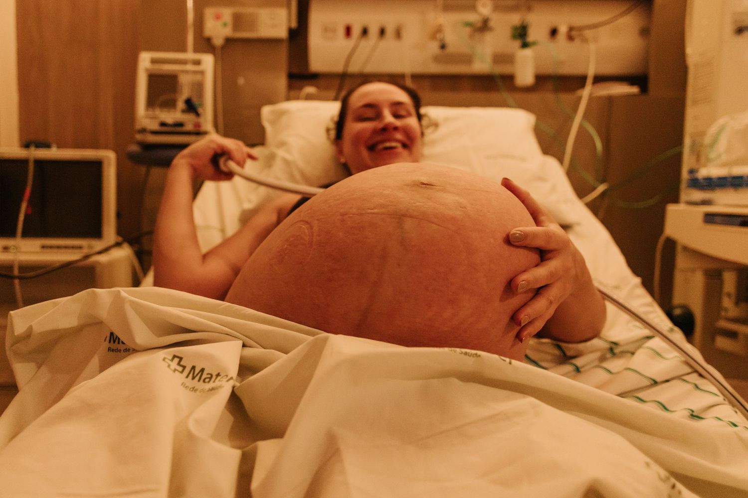 Patient lying on hospital bed during labor preparation.