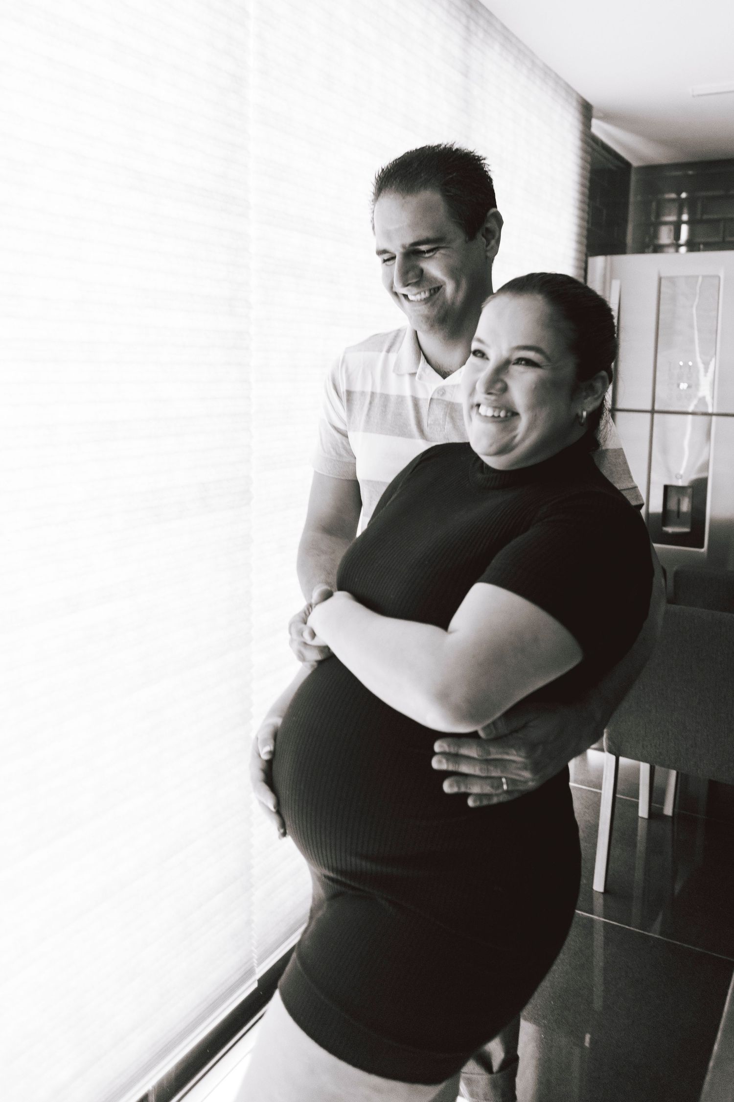 A series of three black and white photos showing two people sharing a warm embrace in an indoor setting.