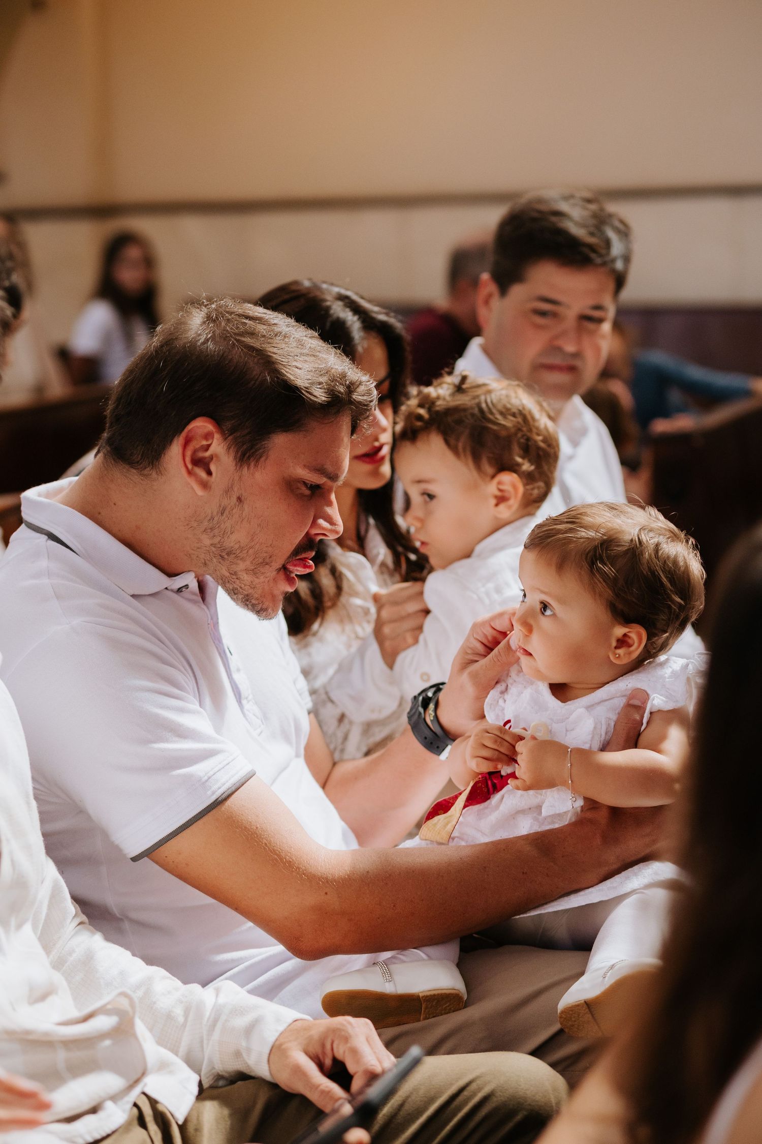 A series of tender moments between a parent and young child in white clothing, showing their loving interaction.