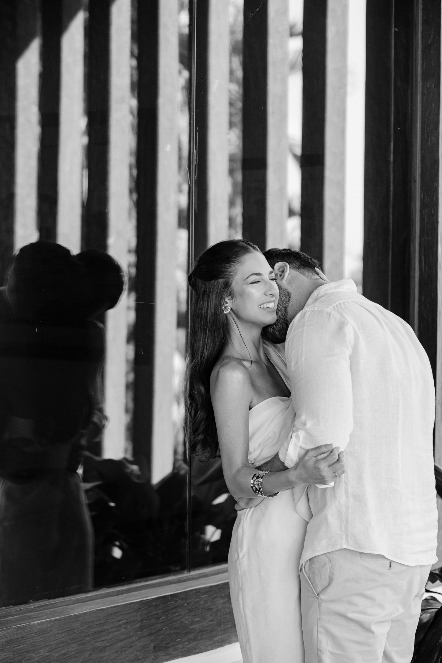A romantic black and white moment captured between a couple with dramatic window light.