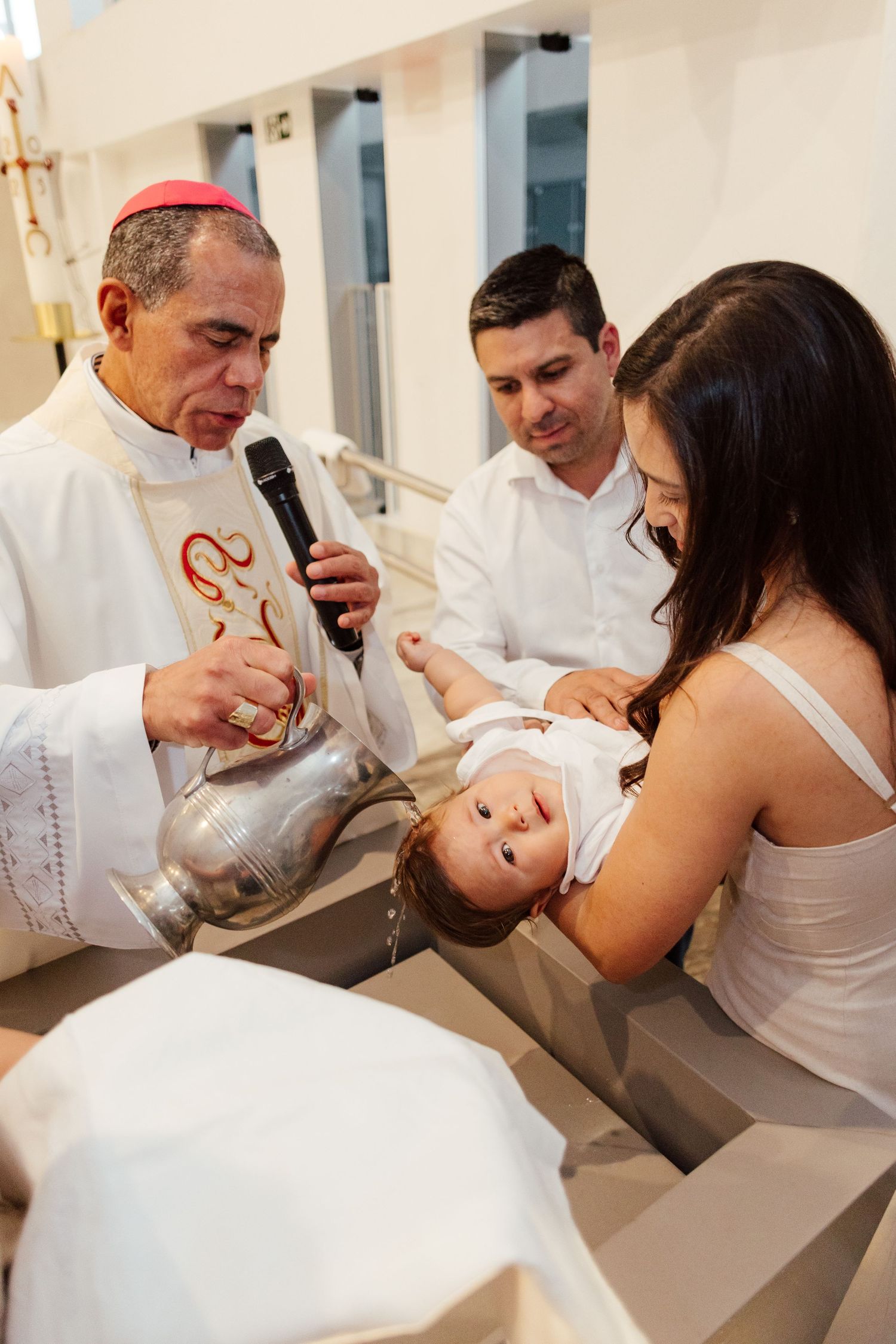 A series of photos showing a baby being signed during a religious ceremony at a church.