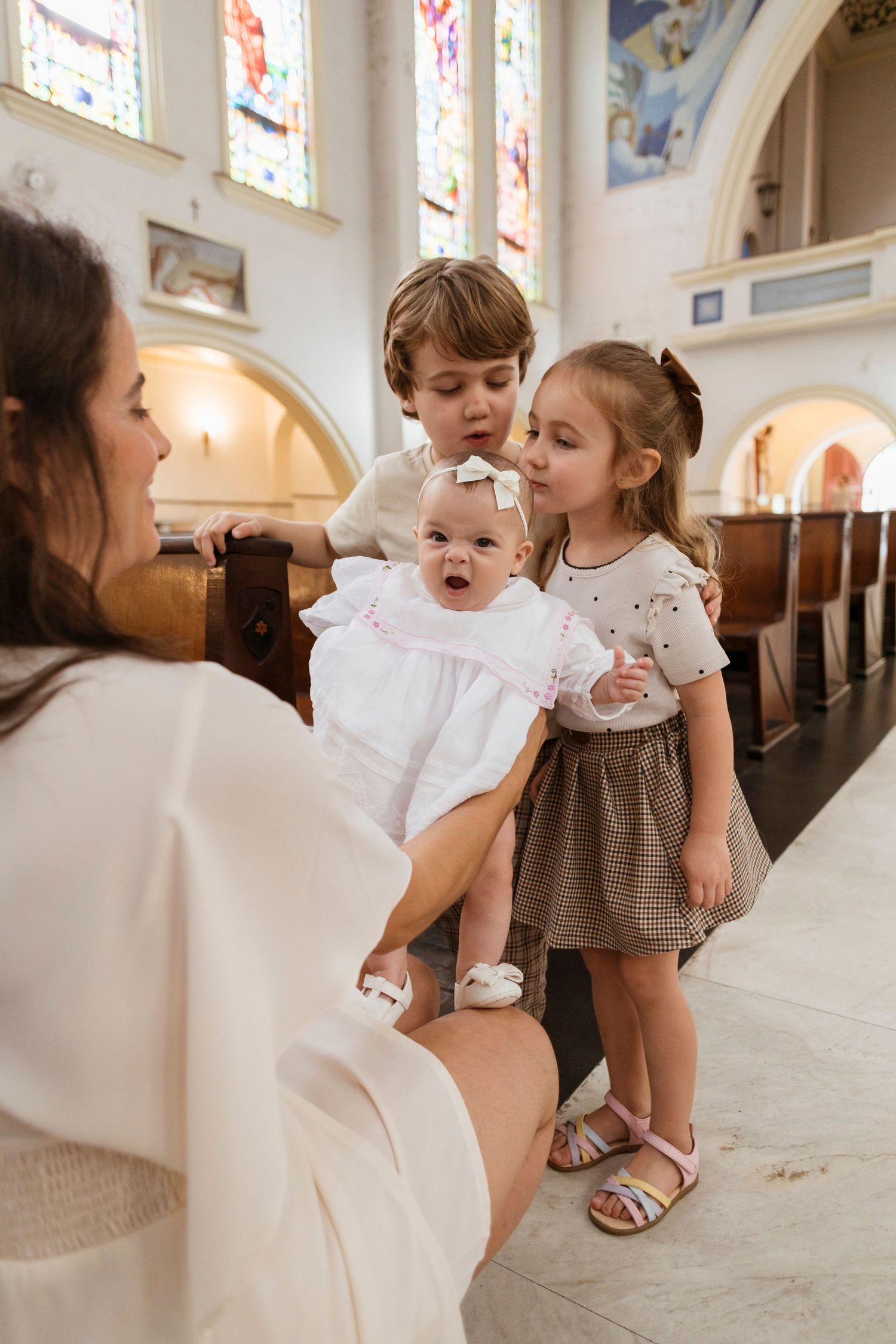 A special religious ceremony with children gathered in a church with stained glass windows.