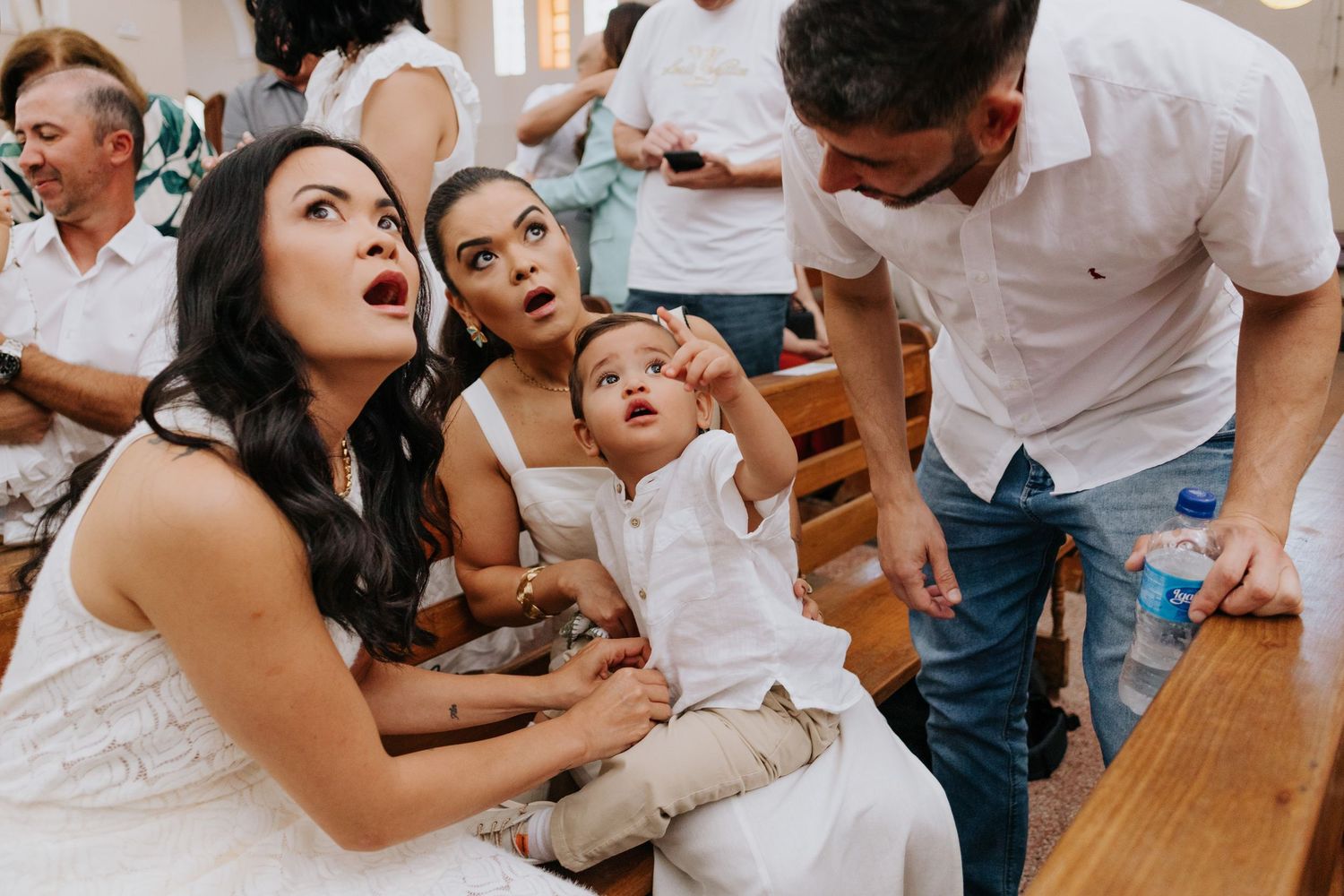 A group of people in white outfits gather around a table during what appears to be a social celebration.