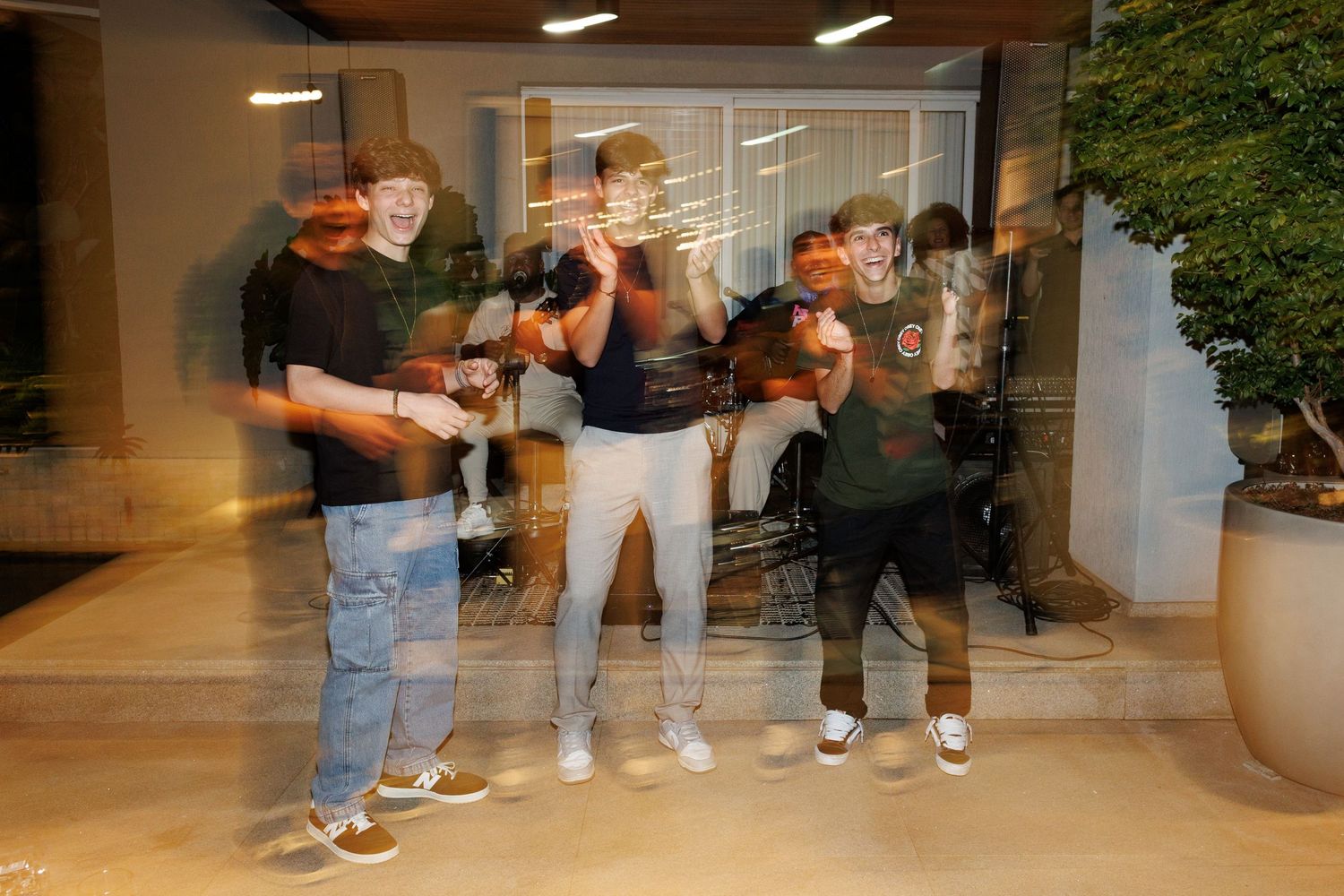 A group of people posing together in a modern office lobby with motion blur effect.
