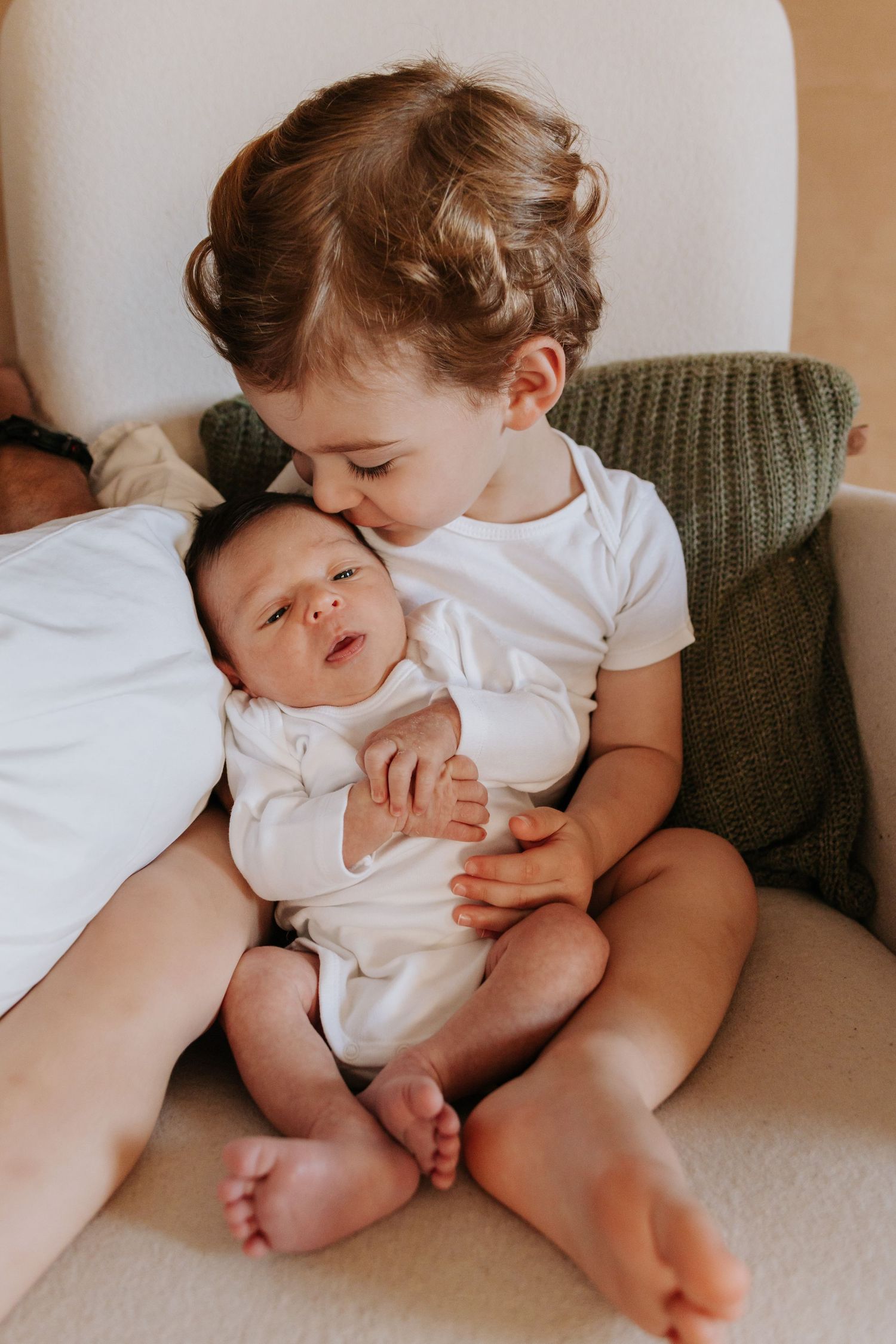 A series of tender moments showing a baby in white clothing resting on a couch.