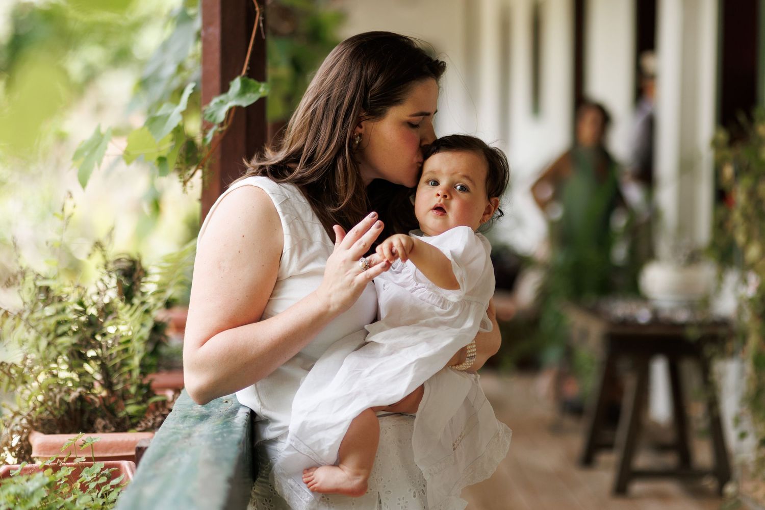 A tender moment captured between mother and child on a rustic outdoor porch with soft natural lighting.