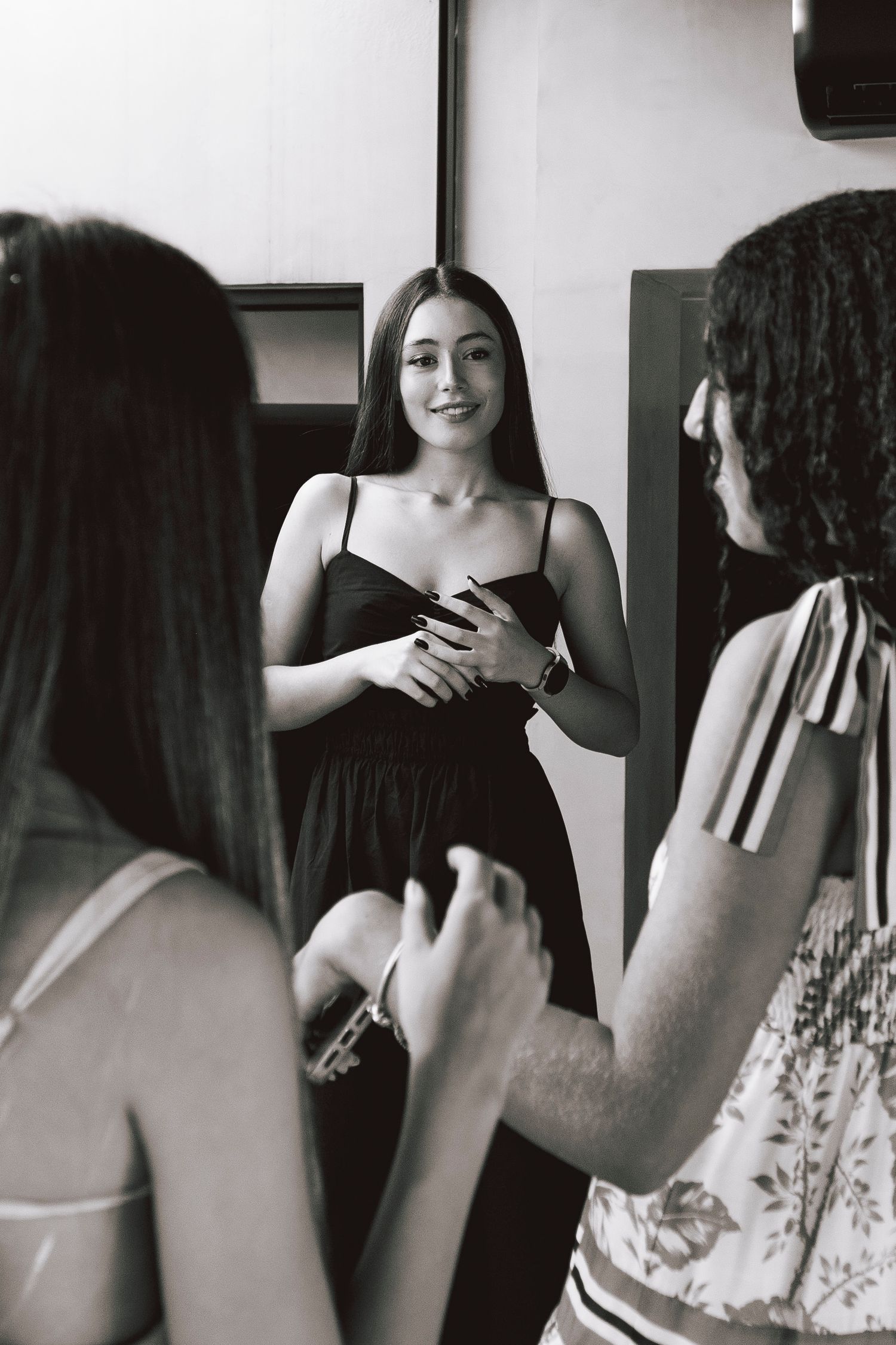 Black and white candid photo of friends chatting and laughing together.