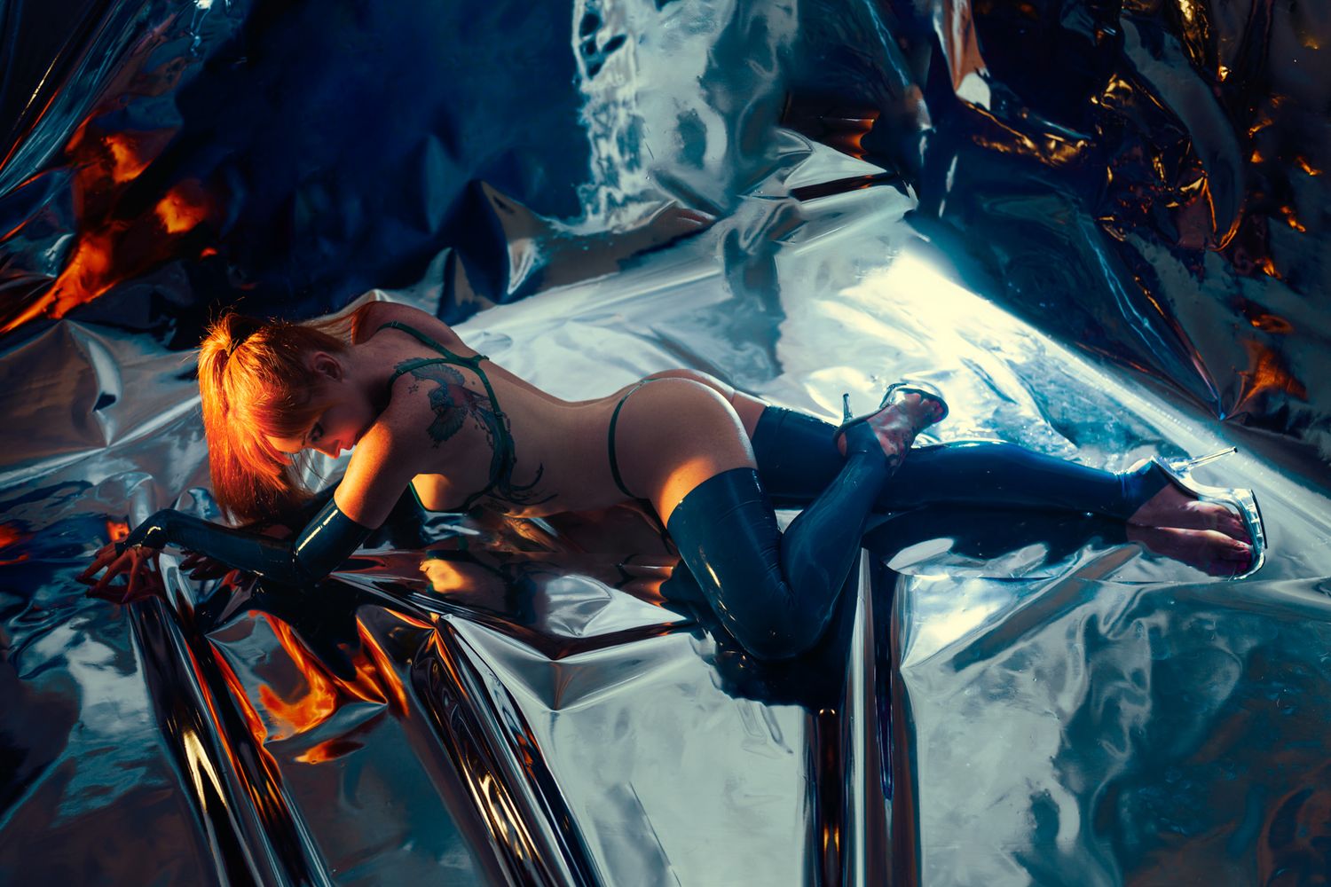 Artistic photo with dramatic lighting showing a figure against a reflective dark surface.