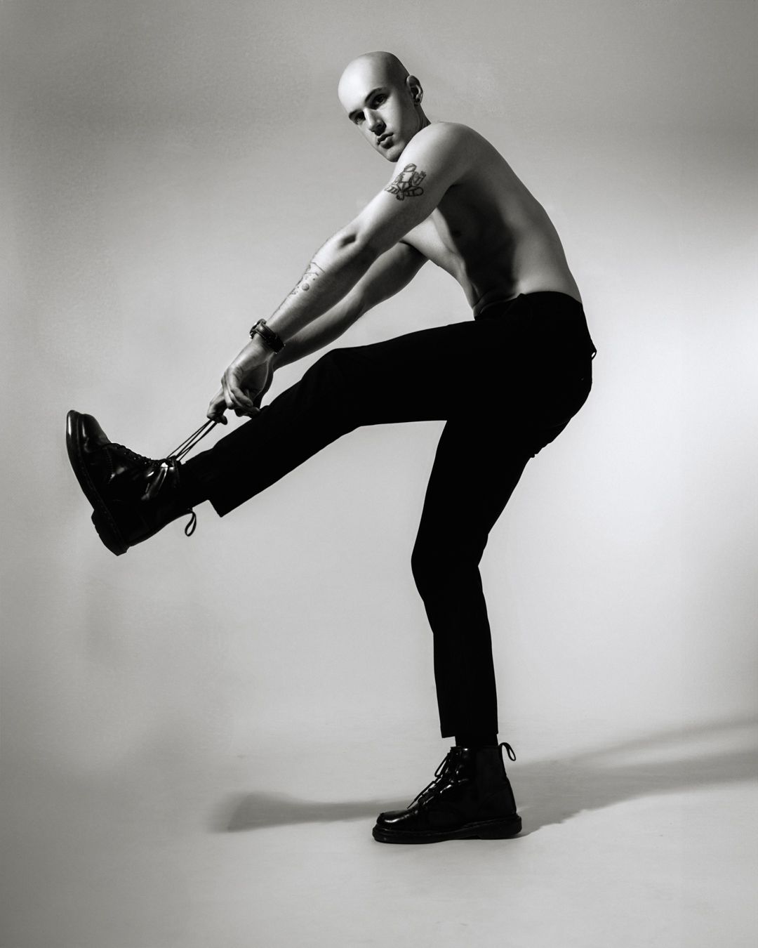 Dramatic black and white dance portrait of figure in motion with boots.