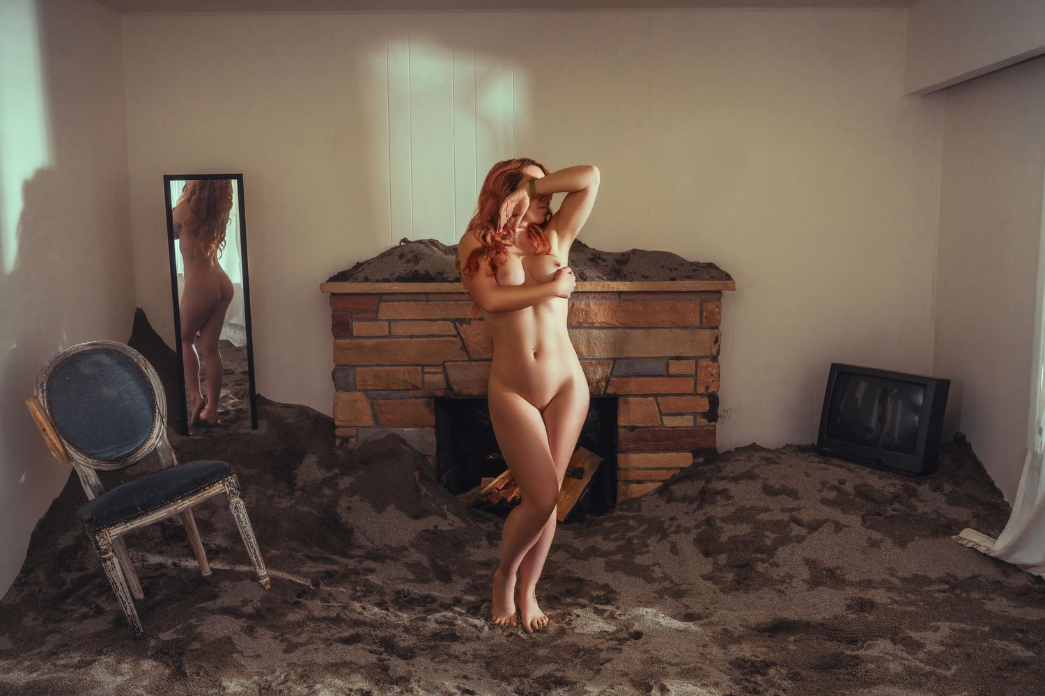 Artistic boudoir photo with rustic brick backdrop and vintage furniture.