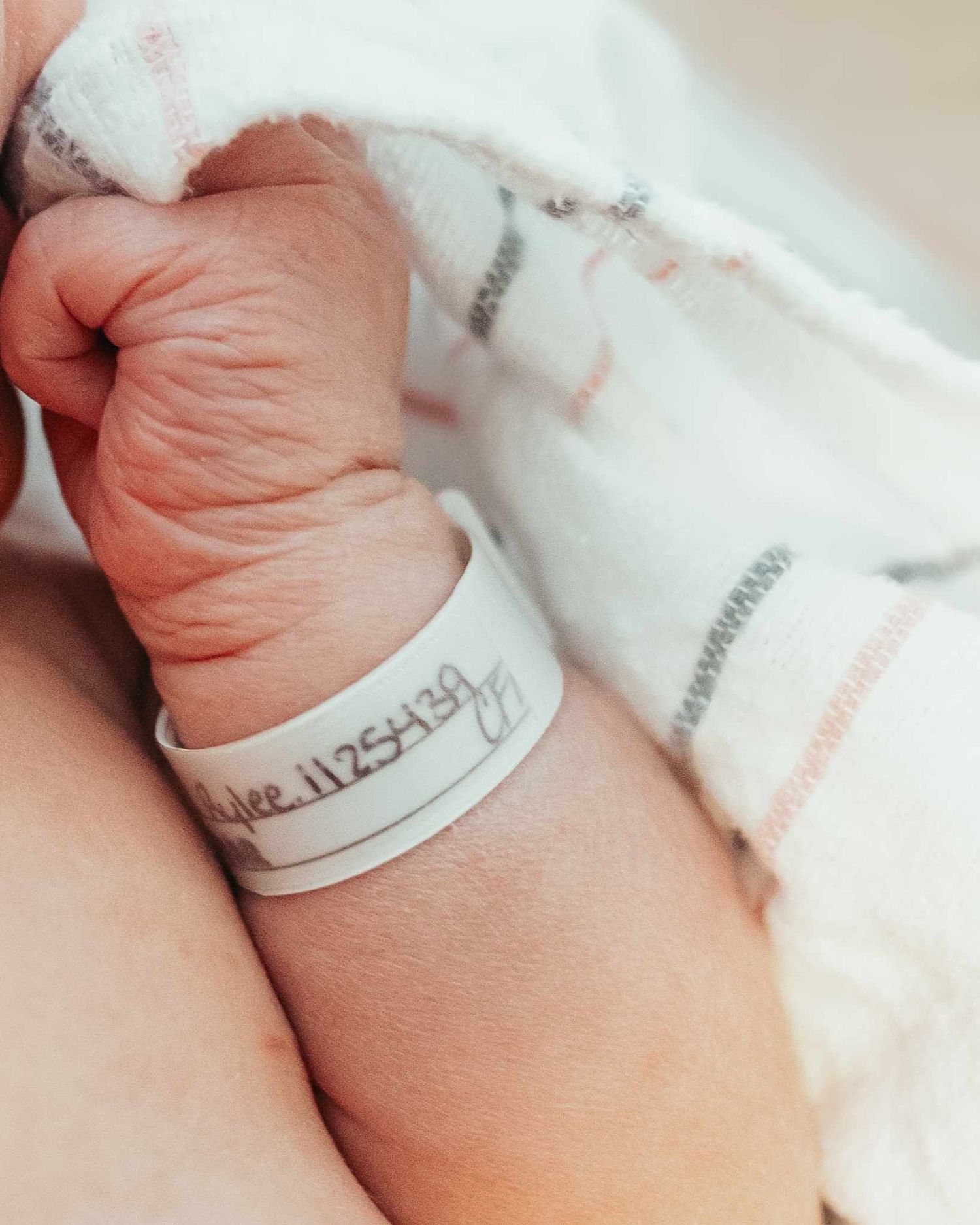 Infant arm and hand with hospital bracelet.
