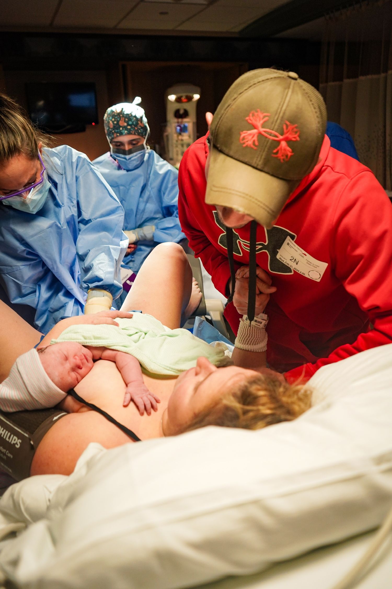 Medical professionals in blue and red scrubs attend to a patient during a medical procedure.