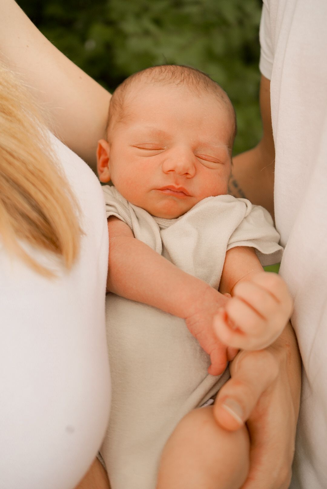Close-up portrait of a sleeping baby being held in loving arms.