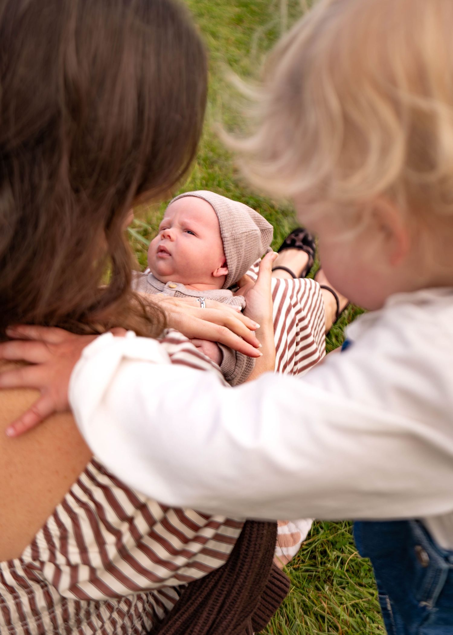 A tender moment captured in a series of photos showing a parent and child embracing on green grass.