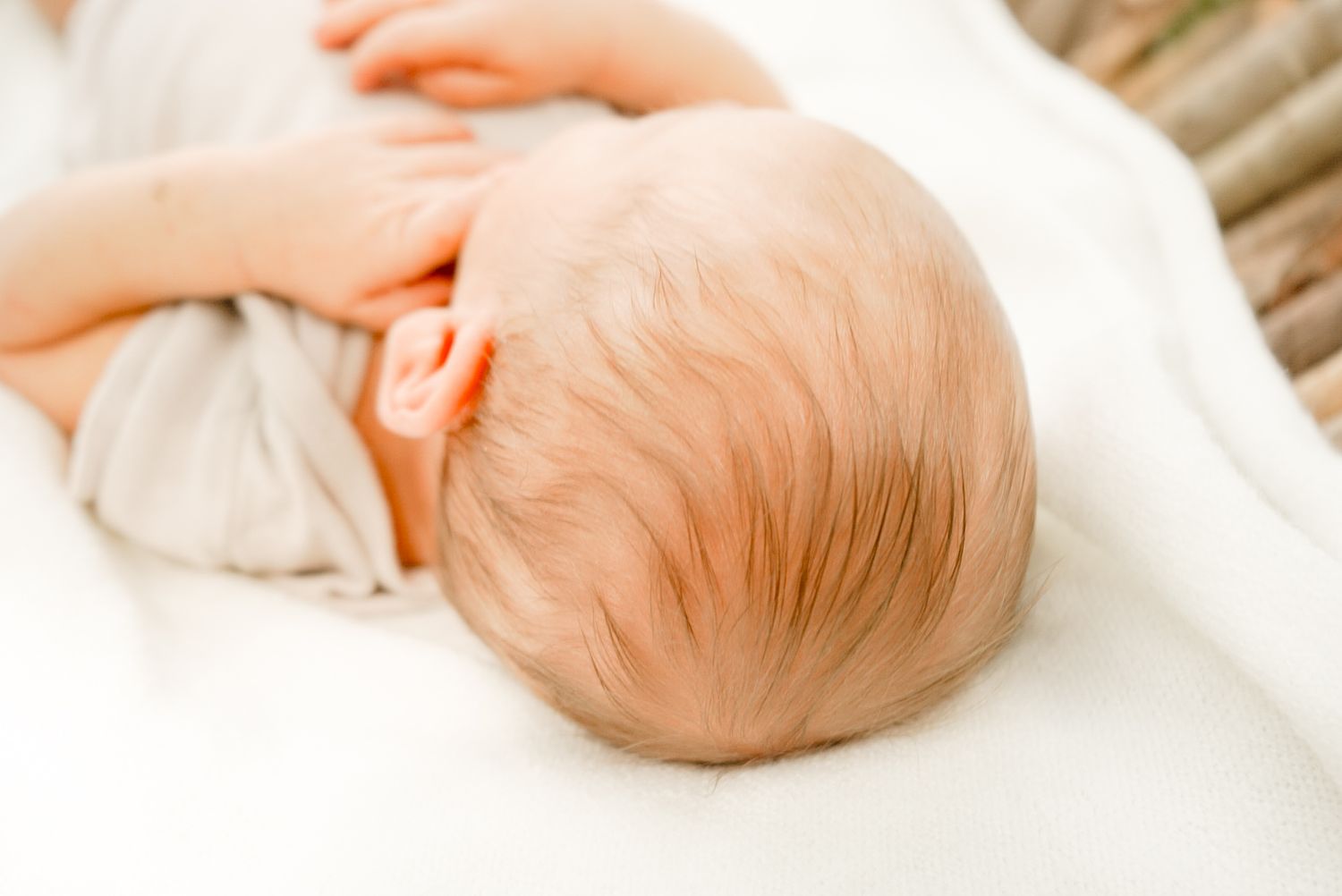 Detailed view of infant massage techniques being demonstrated on a baby's head and neck.